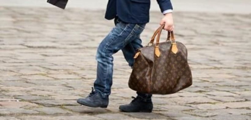 Boy carrying a purse