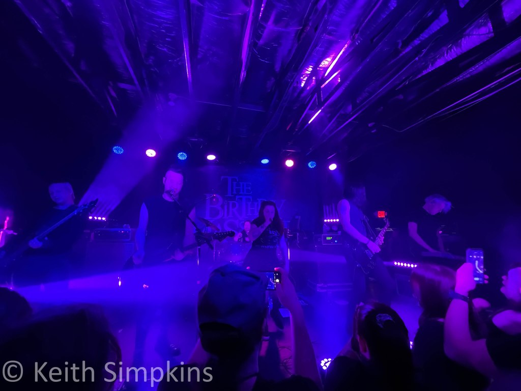 six members of the band The Birthday Massacre at a concert venue