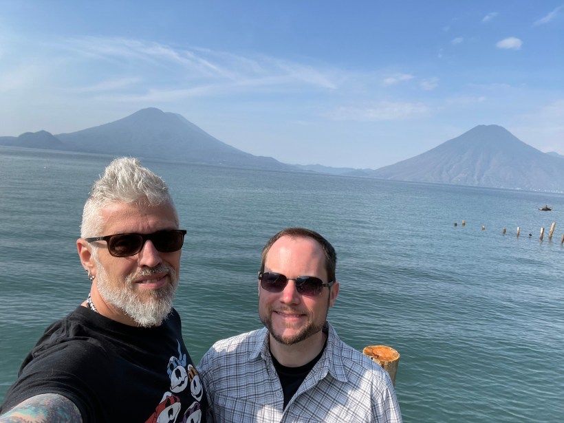 Two men with two volcanoes in the background on Lake Atitlan, Guatemala